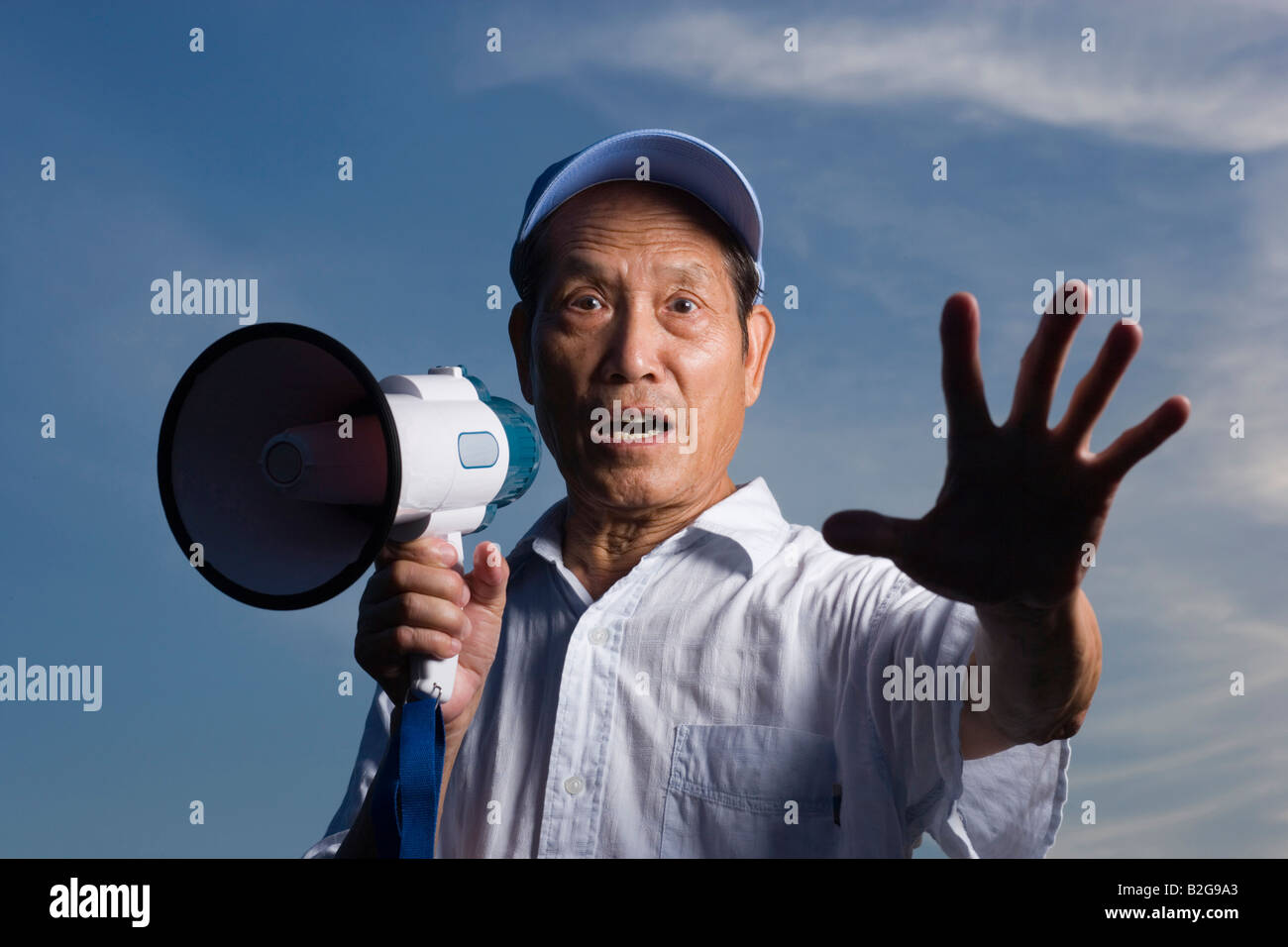 Portrait of a senior man holding a megaphone and gesturing Banque D'Images