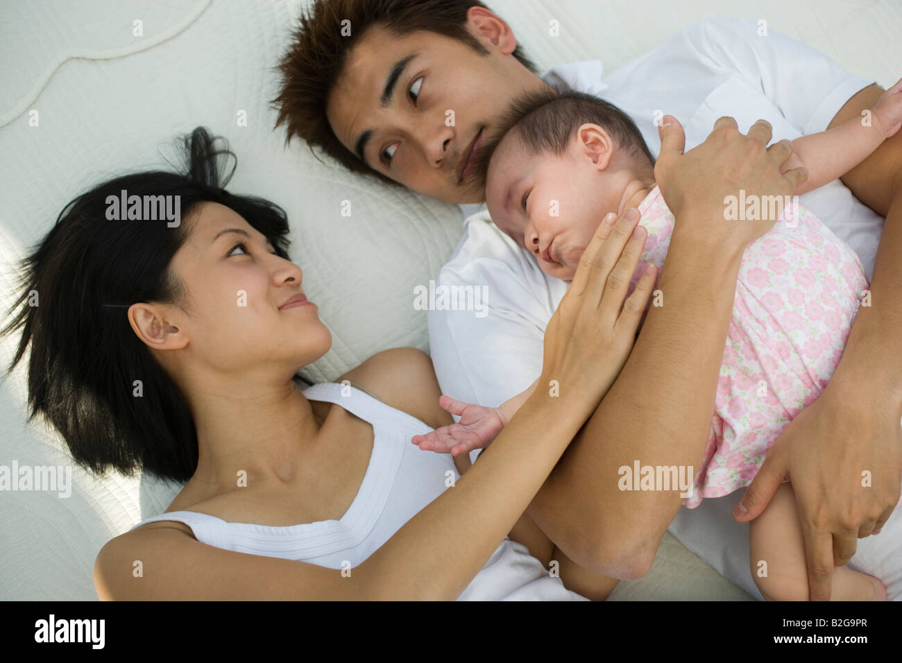 Couple lying on the bed avec leur fille Banque D'Images