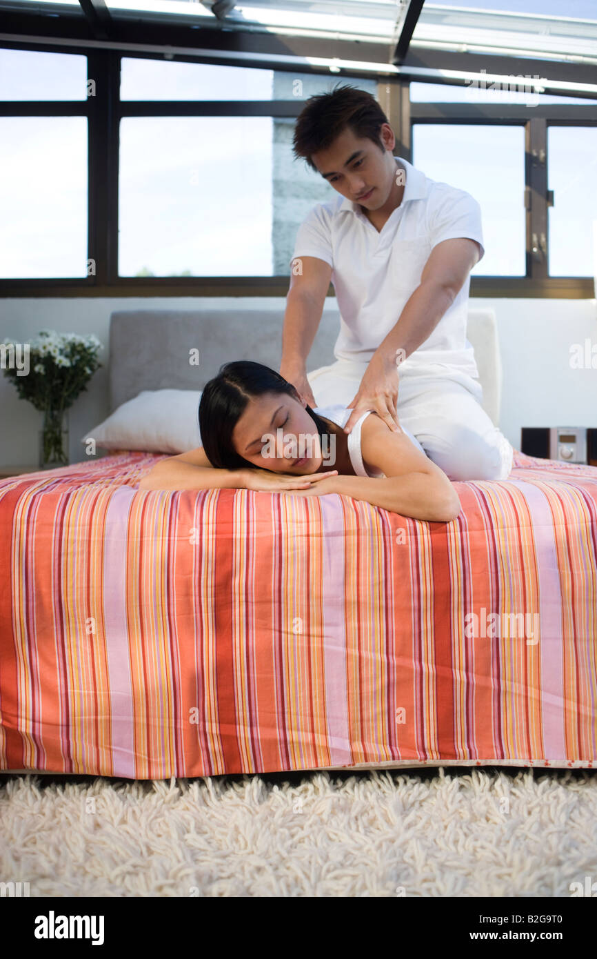 Mid adult woman getting massage de l'épaule d'un jeune homme Banque D'Images