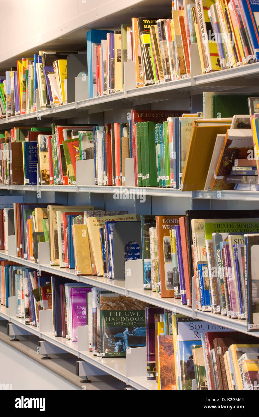 Gros plan d'une étagère dans une bibliothèque, remplie de livres de différentes tailles et couleurs. Banque D'Images