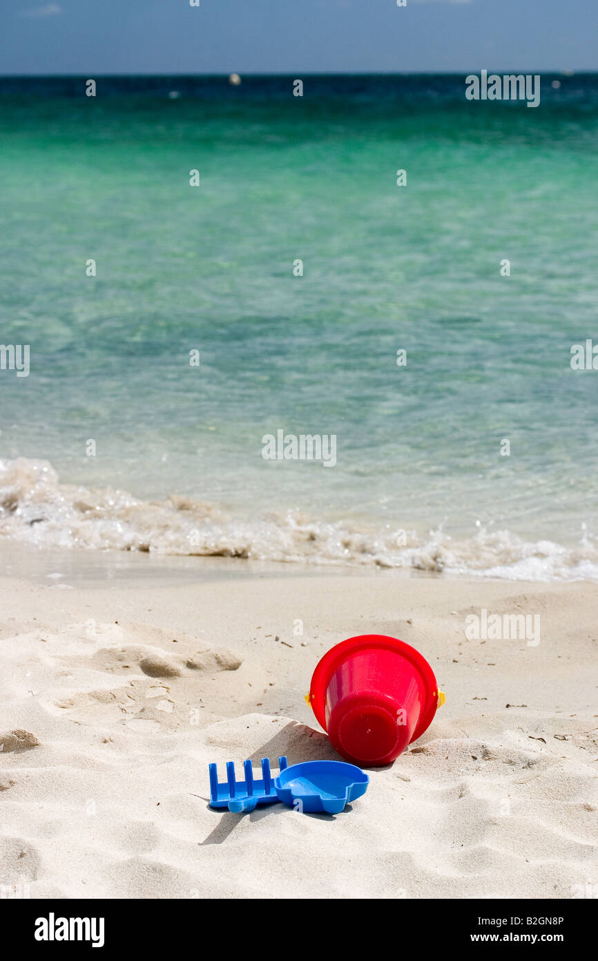 Jouets pour enfants sur la plage de sable blanc avec de l'eau de mer claire en arrière-plan Banque D'Images