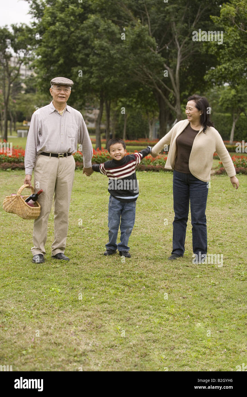 Couple avec leur petit-fils debout dans un parc et smiling Banque D'Images