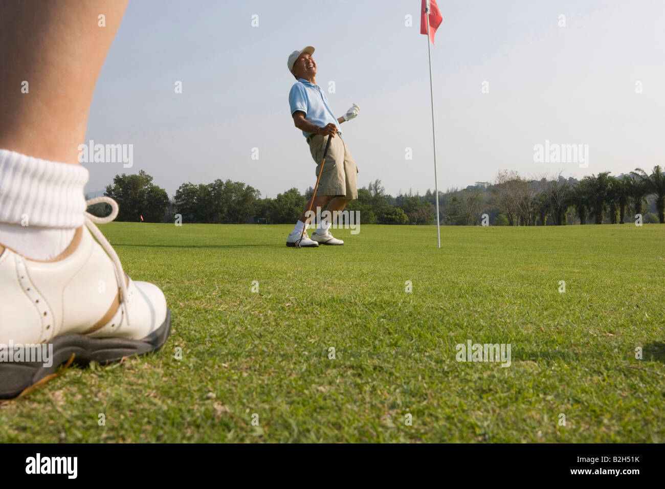 Up d'un joueur de golf avec un homme mûr en jouant au golf dans l'arrière-plan Banque D'Images