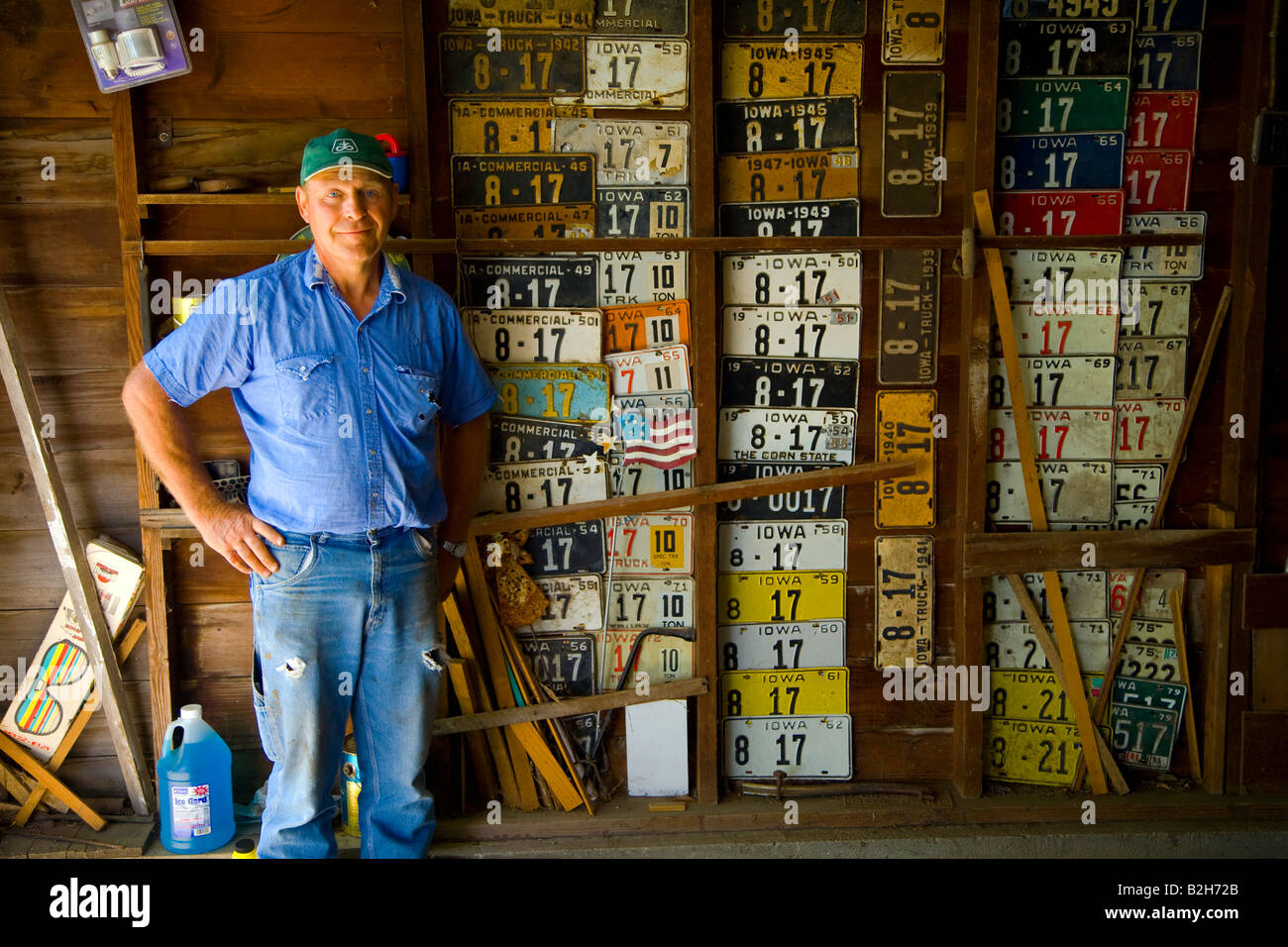 Agriculteur de garage en face de l'ensemble de ses familles liscence les plaques de l 1920 s Banque D'Images