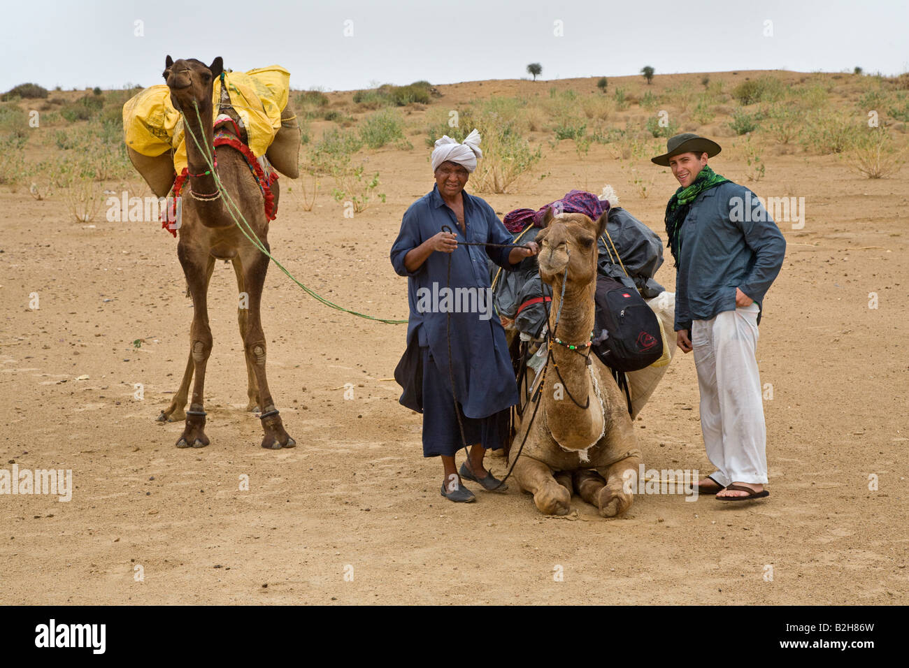 Un touriste se prépare à monter sur le chameau lors d'un safari dans le désert du Thar près de Jaisalmer RAJASTHAN INDE M. Banque D'Images
