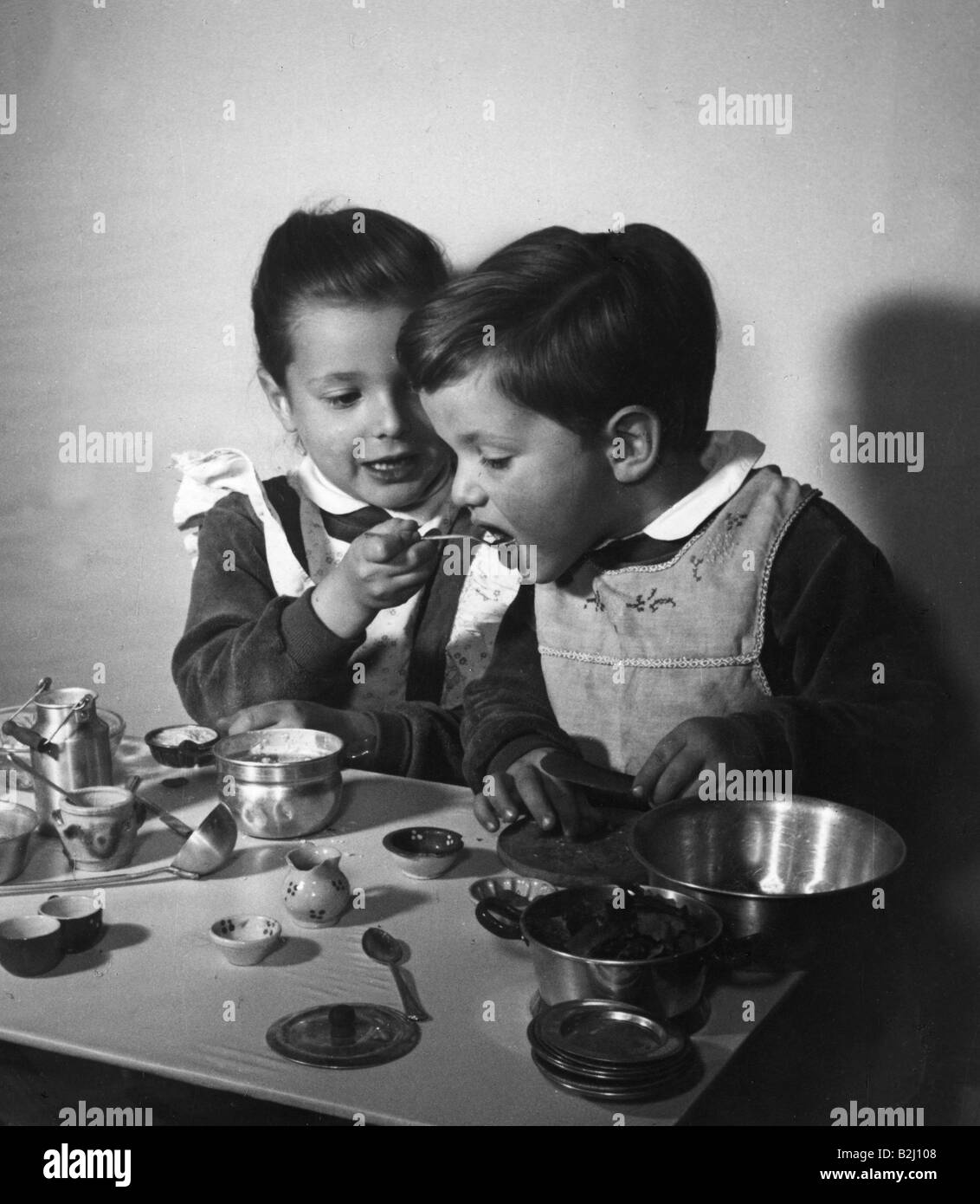 les gens, les enfants / les enfants, jouer, les filles et les garçons faire cuire un gâteau avec des plats de jouets, années 1950, Banque D'Images