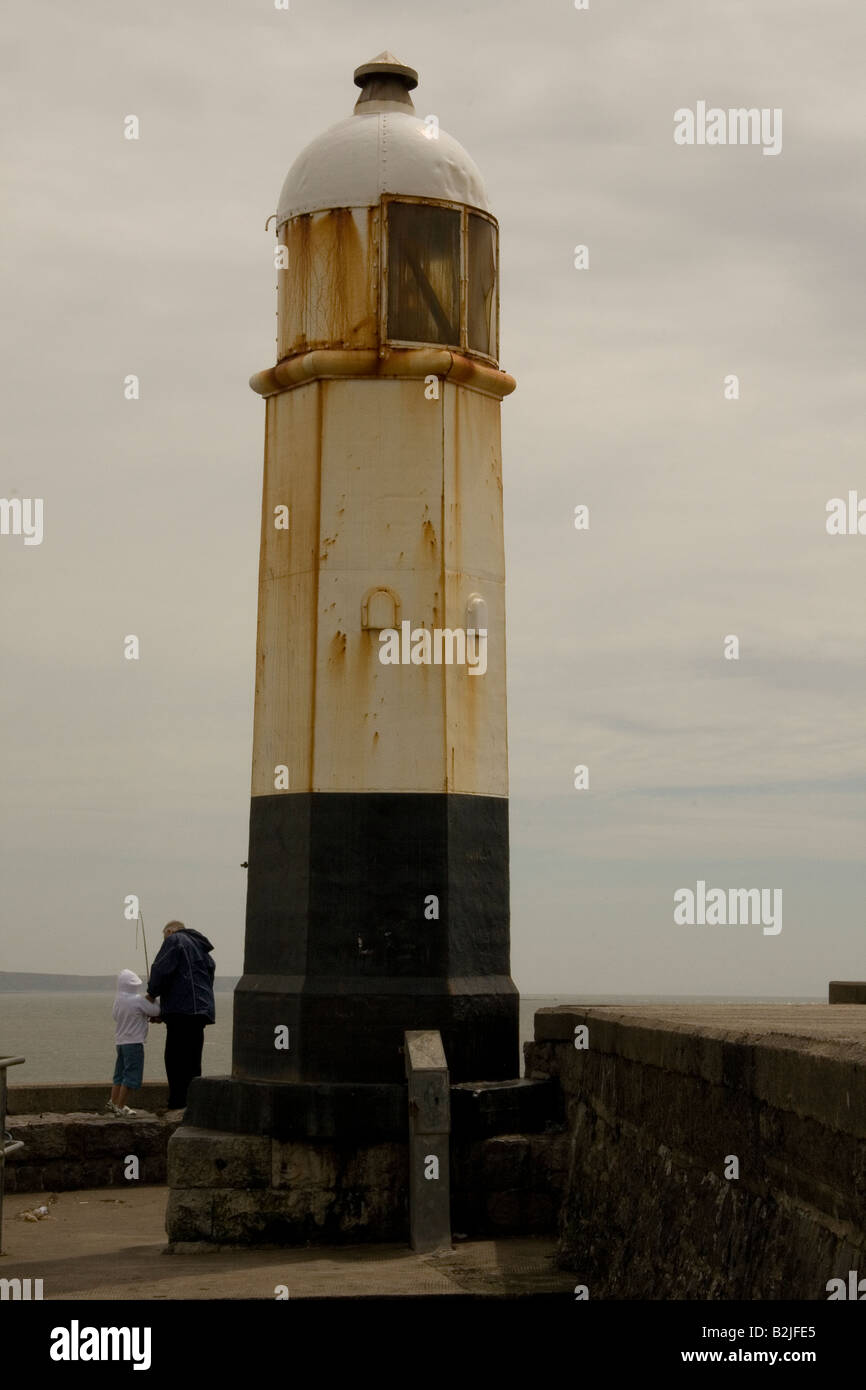 Grand-père et petit-fils de pêche Porthcawl phare à l'extrémité du brise-lames du port de Porthcawl, S Pays de Galles UK GO Banque D'Images