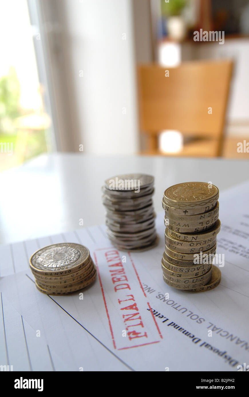 Une pile de pièces d'être comptés, d'essayer de payer les factures de la demande finale / / rappel / red bill. Banque D'Images