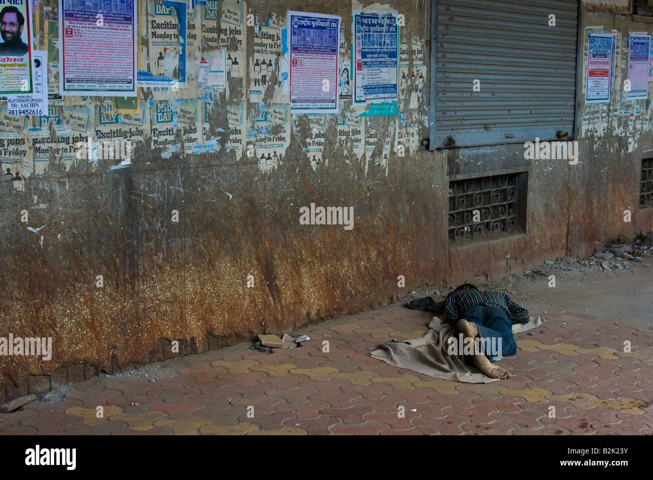 Garçon sans-abri dormant dans la rue à Mumbai Inde Banque D'Images