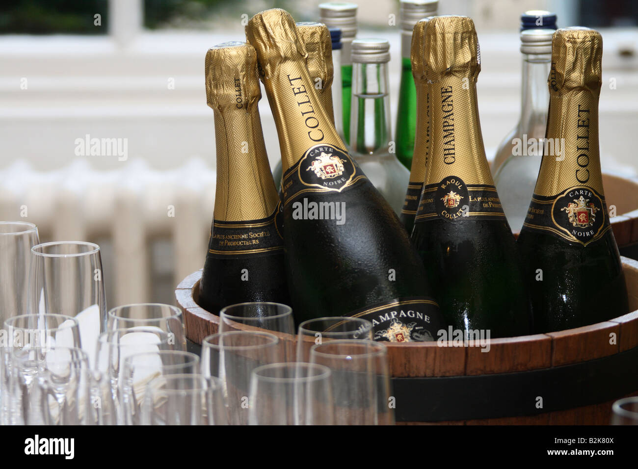 Des bouteilles de champagne dans un seau à glace avec des lunettes à côté Banque D'Images