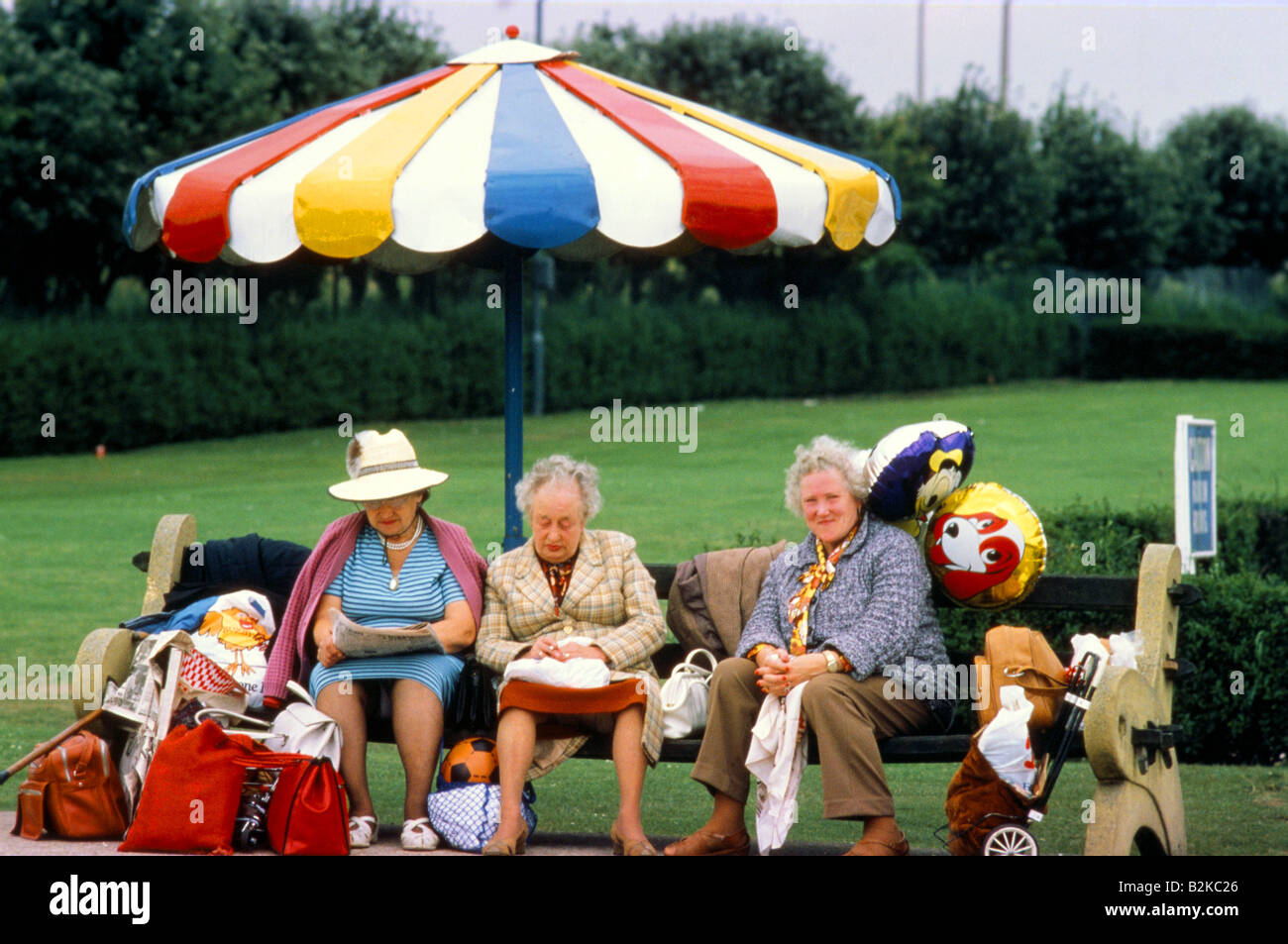 Les vacanciers âgés SE REPOSANT SUR UN BANC AVEC UNE ASSURANCE À BUTLINS Banque D'Images