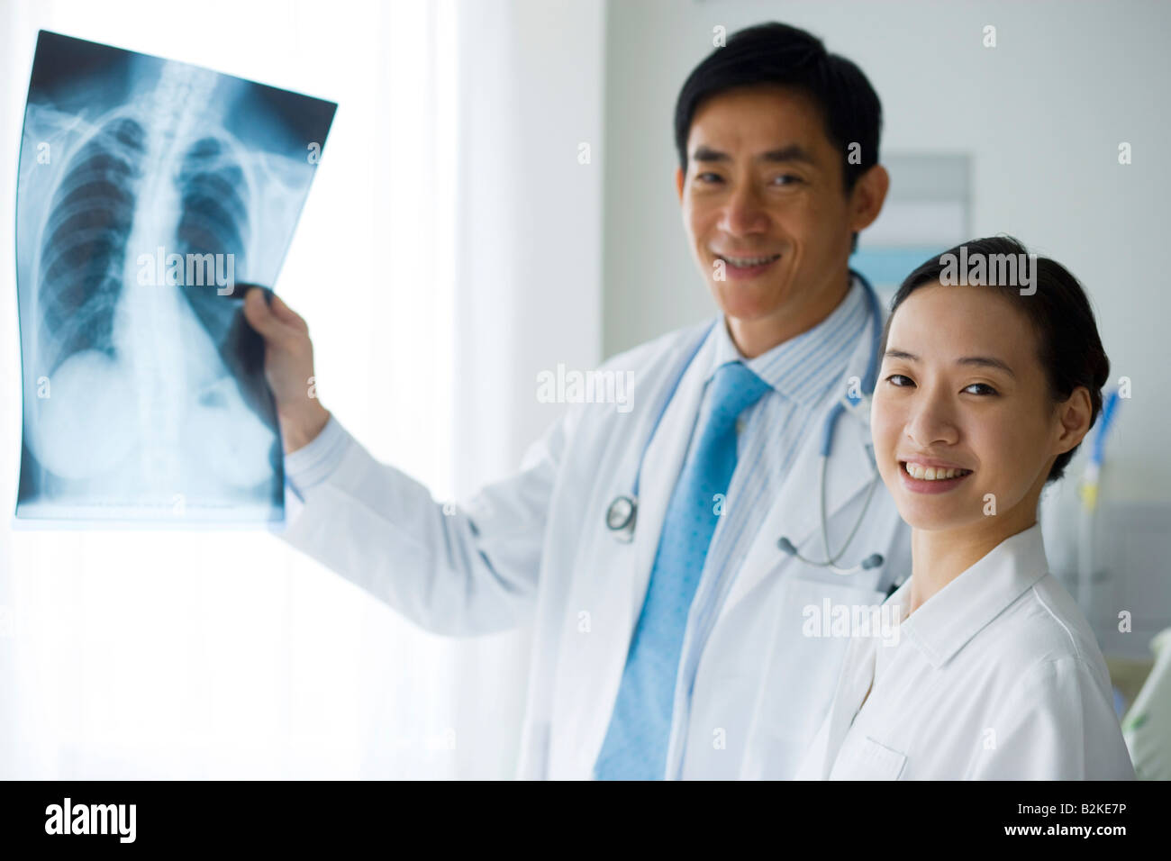 Male doctor holding X-Ray un rapport et une infirmière debout à côté de lui Banque D'Images