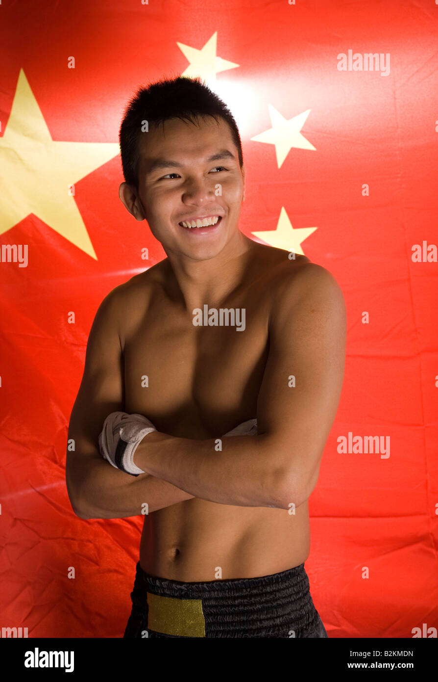 Jeune homme souriant devant un drapeau chinois Banque D'Images