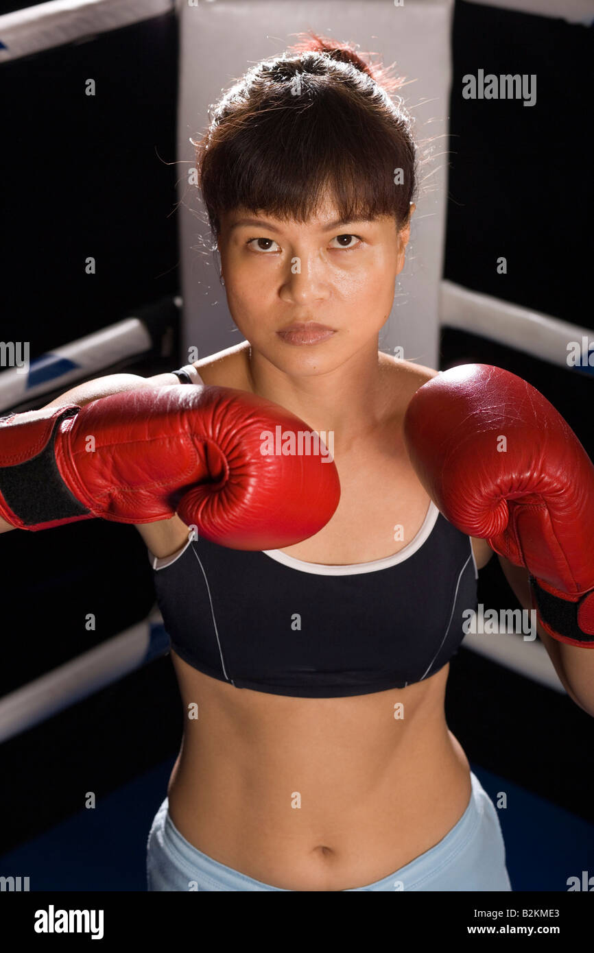 Jeune femme pratiquant la boxe dans un ring de boxe Banque D'Images