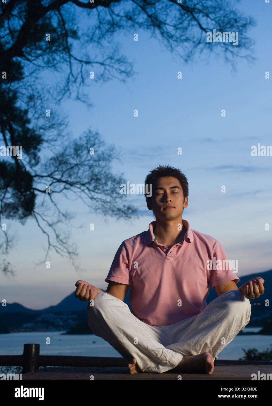 Jeune homme méditant dans une position du lotus Banque D'Images