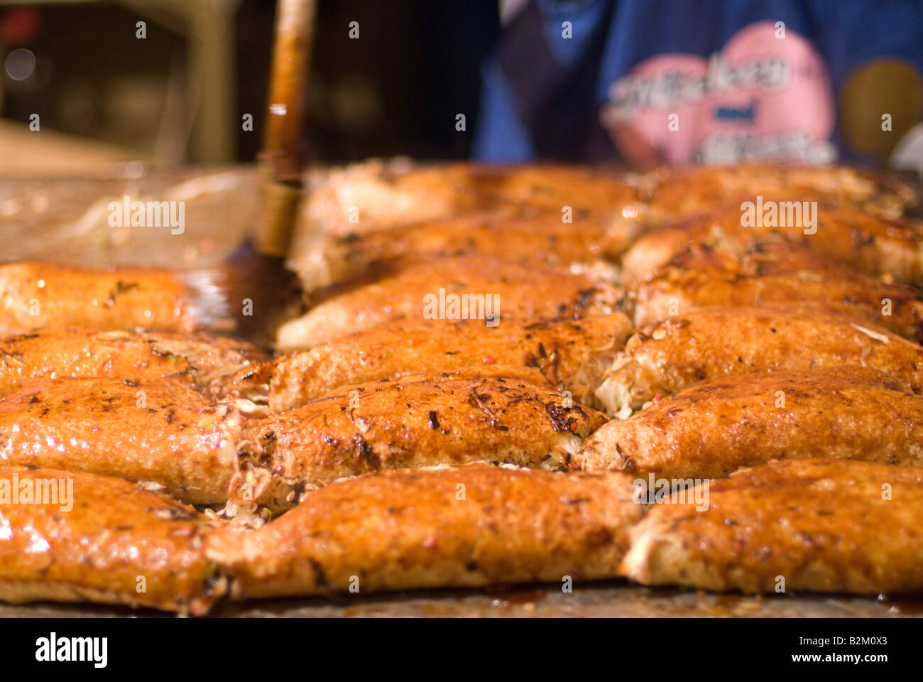 Pancakes salés Okonomiyaki - Japonais - être badigeonnés de sauce à un festival dans le centre du Japon Banque D'Images