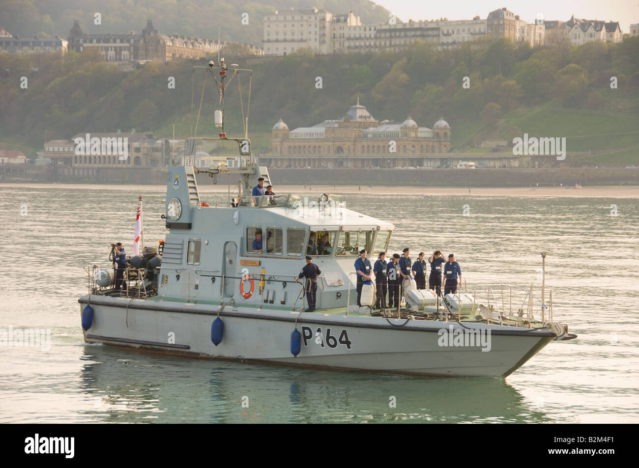 Des cadets de la mer arrivent en bateau au port de South Bay, Scarborough avec le Spa Theatre au loin. ROYAUME-UNI Banque D'Images
