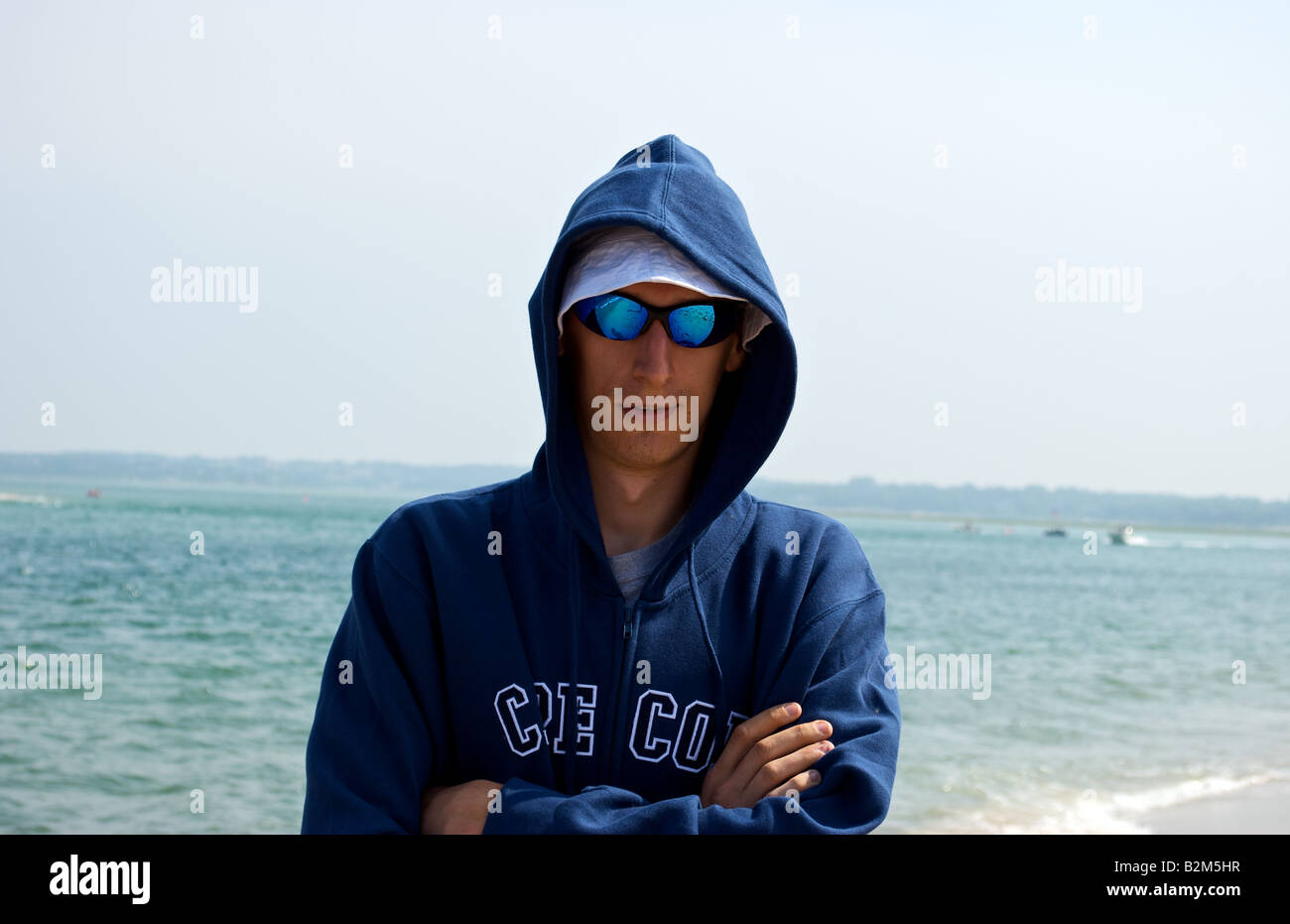 Homme dans la vingtaine, posant pour une photo sur un jour de vent à la plage Banque D'Images