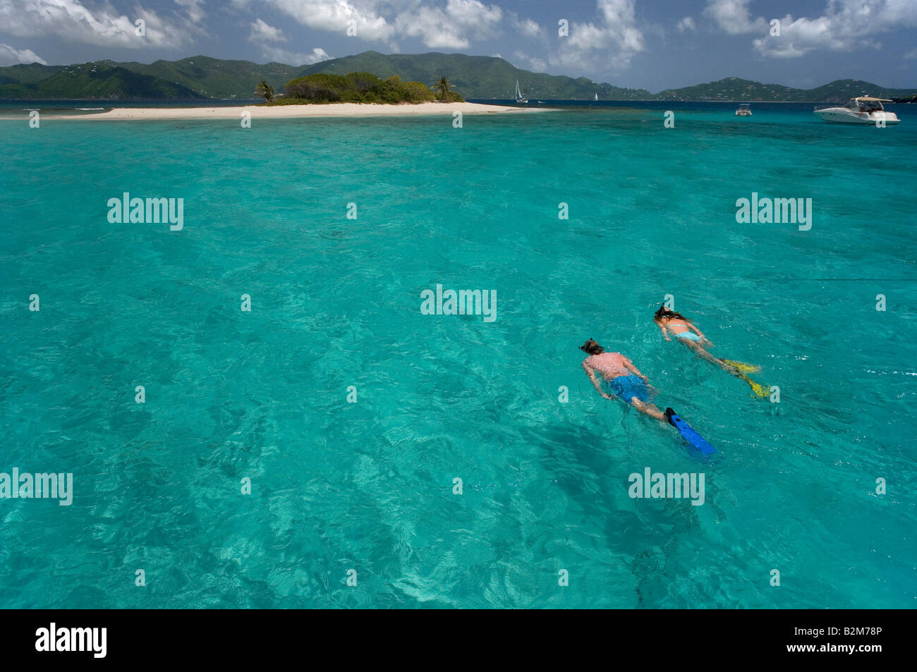 Un couple en apnée vers Sandy Spit Island dans les îles Vierges britanniques Banque D'Images