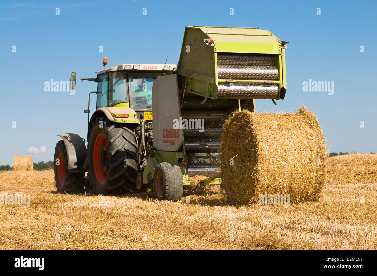 Claas Ares 826 RZ '' et 'Claas Rollant 66 balles de paille" au travail, sud-Touraine, France. Banque D'Images
