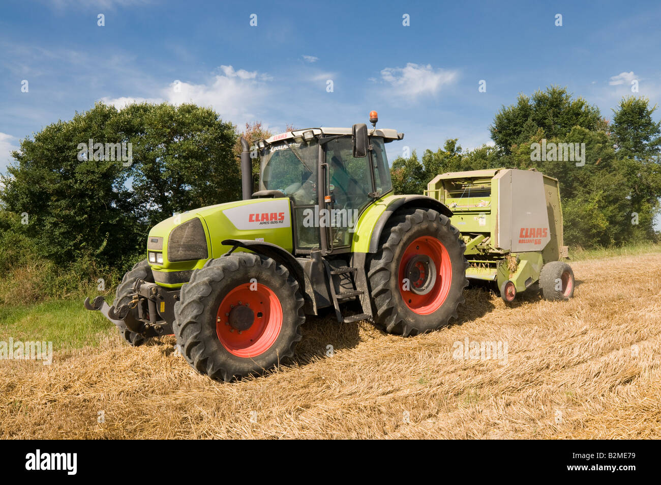 Claas Ares 826 RZ '' et 'Claas Rollant 66 balles de paille" au travail, sud-Touraine, France. Banque D'Images