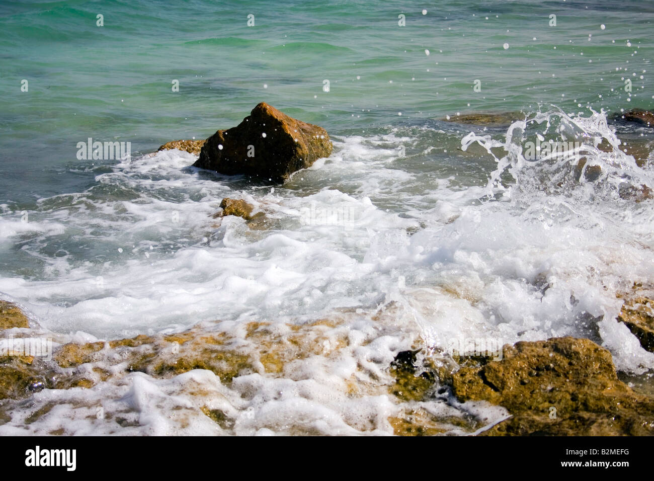 Splash des vagues contre les rochers en mer. Banque D'Images