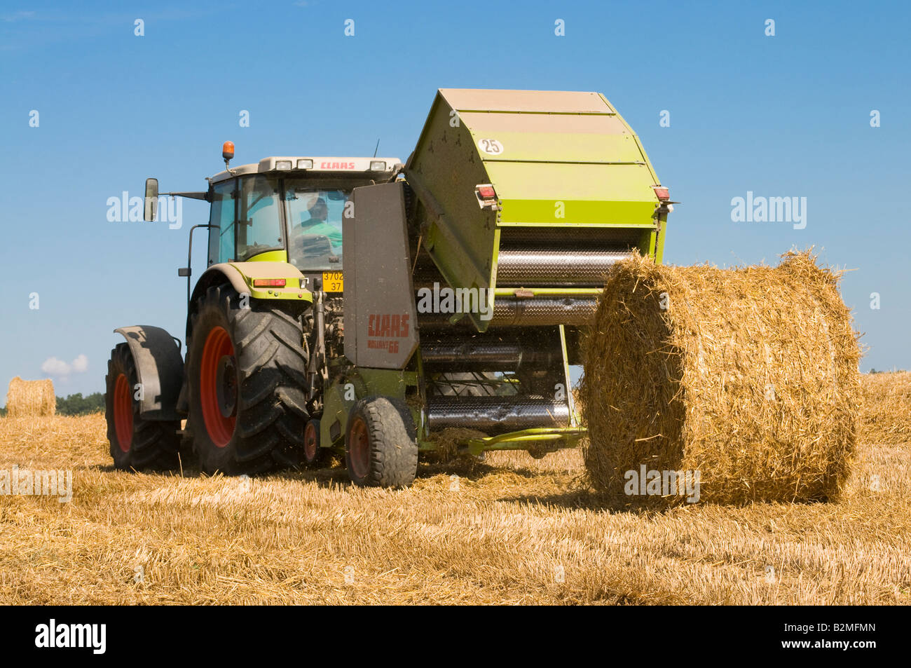 Claas Ares 826 RZ '' et 'Claas Rollant 66 balles de paille" au travail, sud-Touraine, France. Banque D'Images