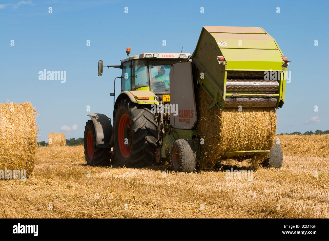 Claas Ares 826 RZ '' et 'Claas Rollant 66 balles de paille" au travail, sud-Touraine, France. Banque D'Images
