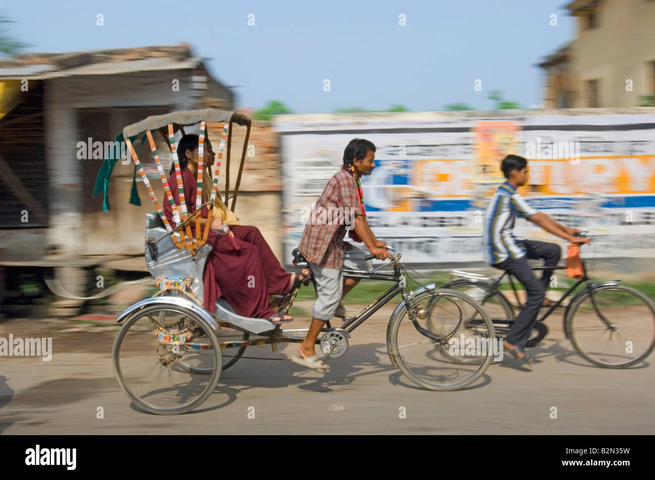 Deux femmes indiennes sur un cycle rickshaw à Varanasi. Vitesse d'obturation lente et le panoramique de flou. Banque D'Images