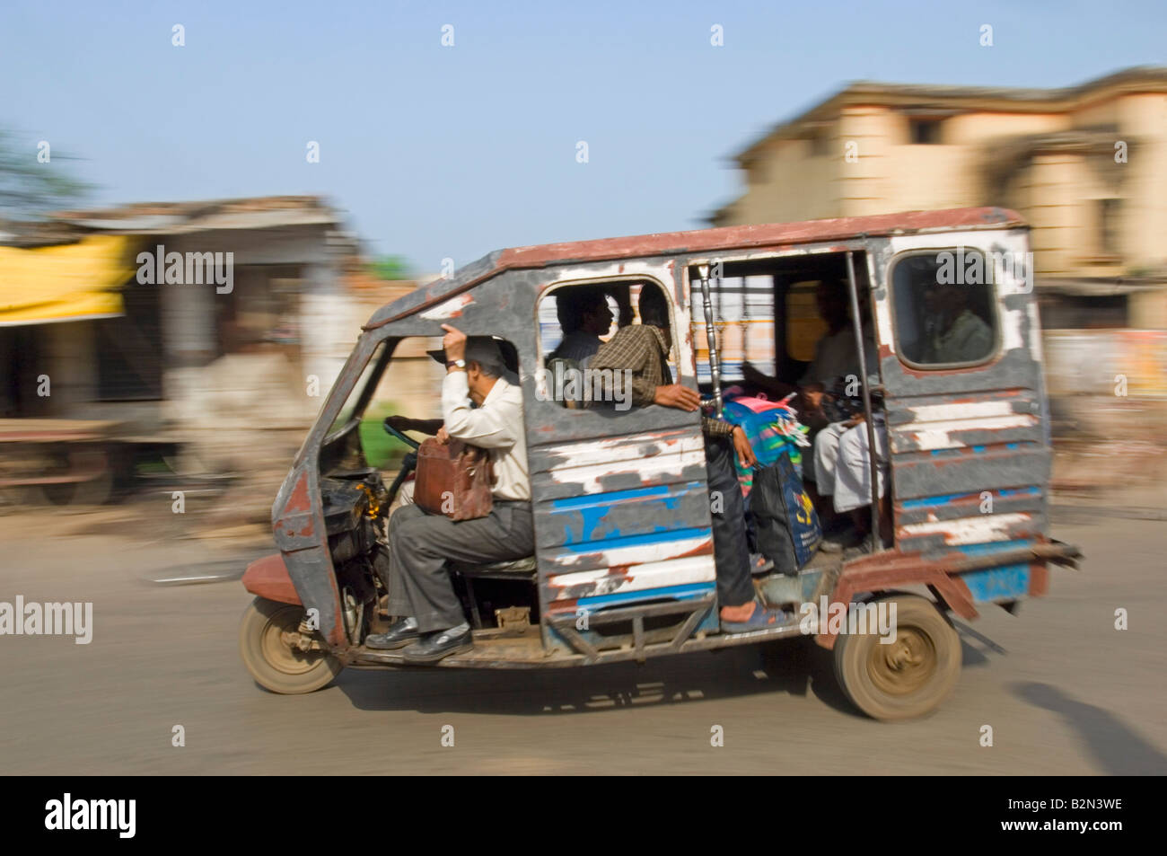 Un auto rickshaw (tuk tuk) et les passagers à Varanasi. Vitesse d'obturation lente et le panoramique de flou. Banque D'Images