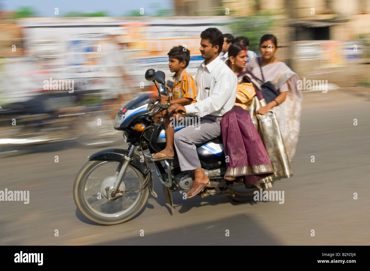 Une famille sur une moto ne portaient pas de casques à Varanasi. Vitesse d'obturation lente et le panoramique de flou. Banque D'Images