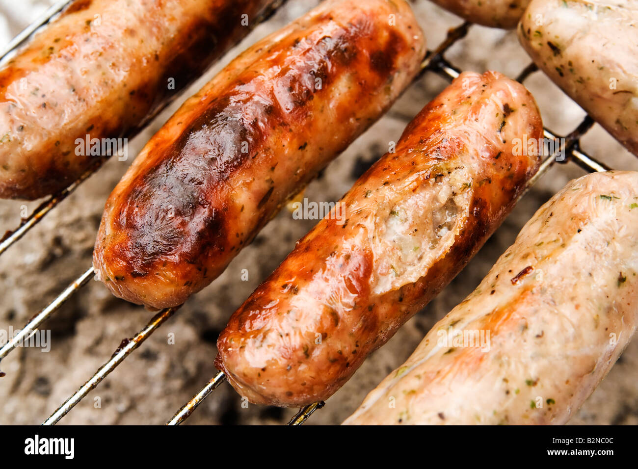 ^saucisses cuisson sur un barbecue, UK. Banque D'Images