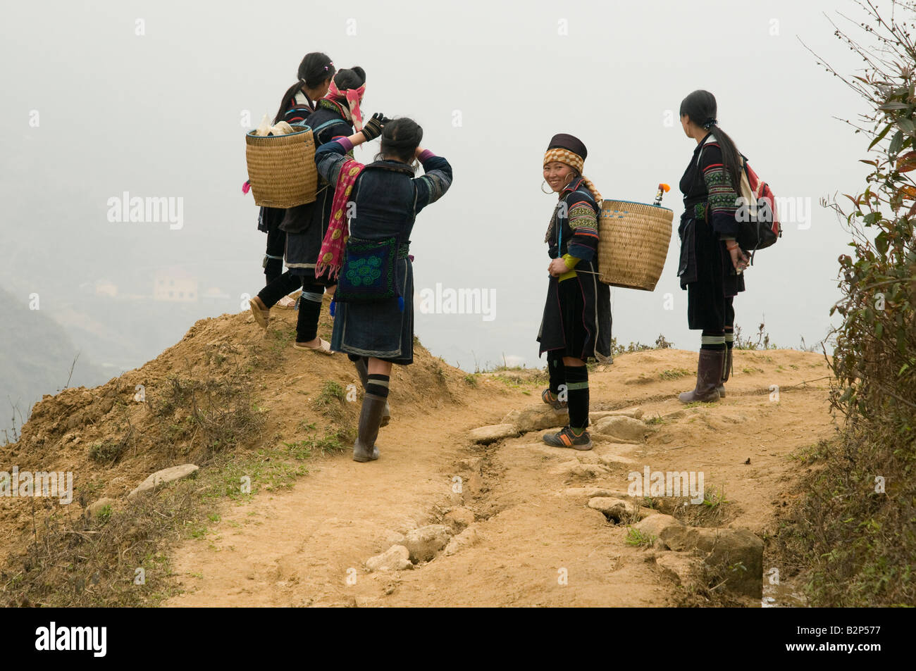 Cinq femmes des tribus Hmong noir sur un Misty Mountain top à Sapa, Vietnam Banque D'Images