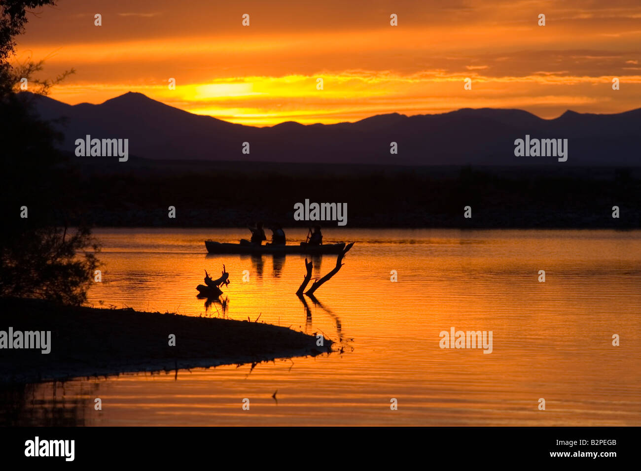 Les pêcheurs tentent leur chance à partir de bateaux sur les eaux d'or d'un lac miroitant au coucher du soleil après une belle journée d'été au Colorado Banque D'Images