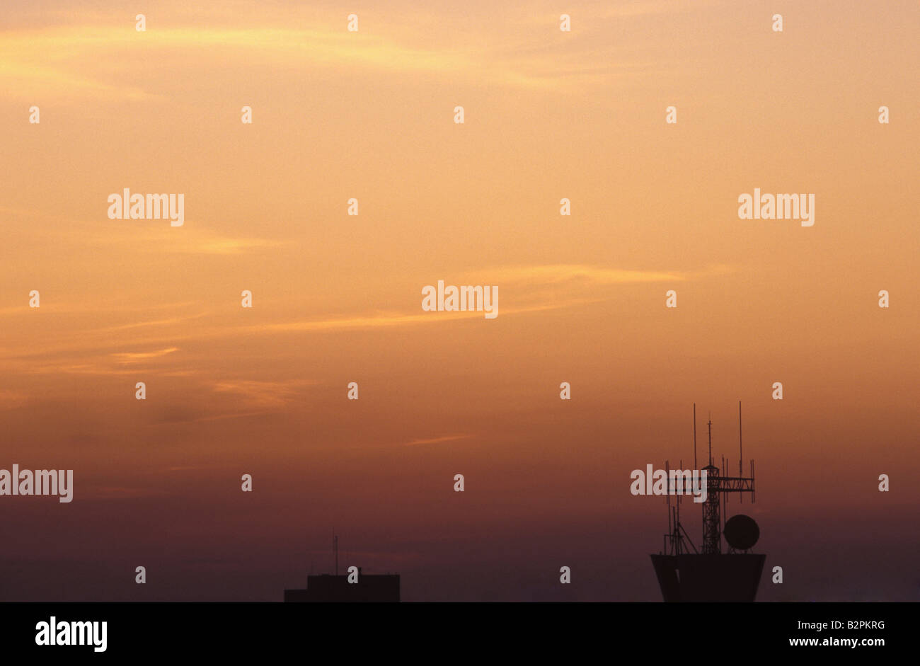 La tour radio contraste avec la fin de la journée ciel orange. Banque D'Images