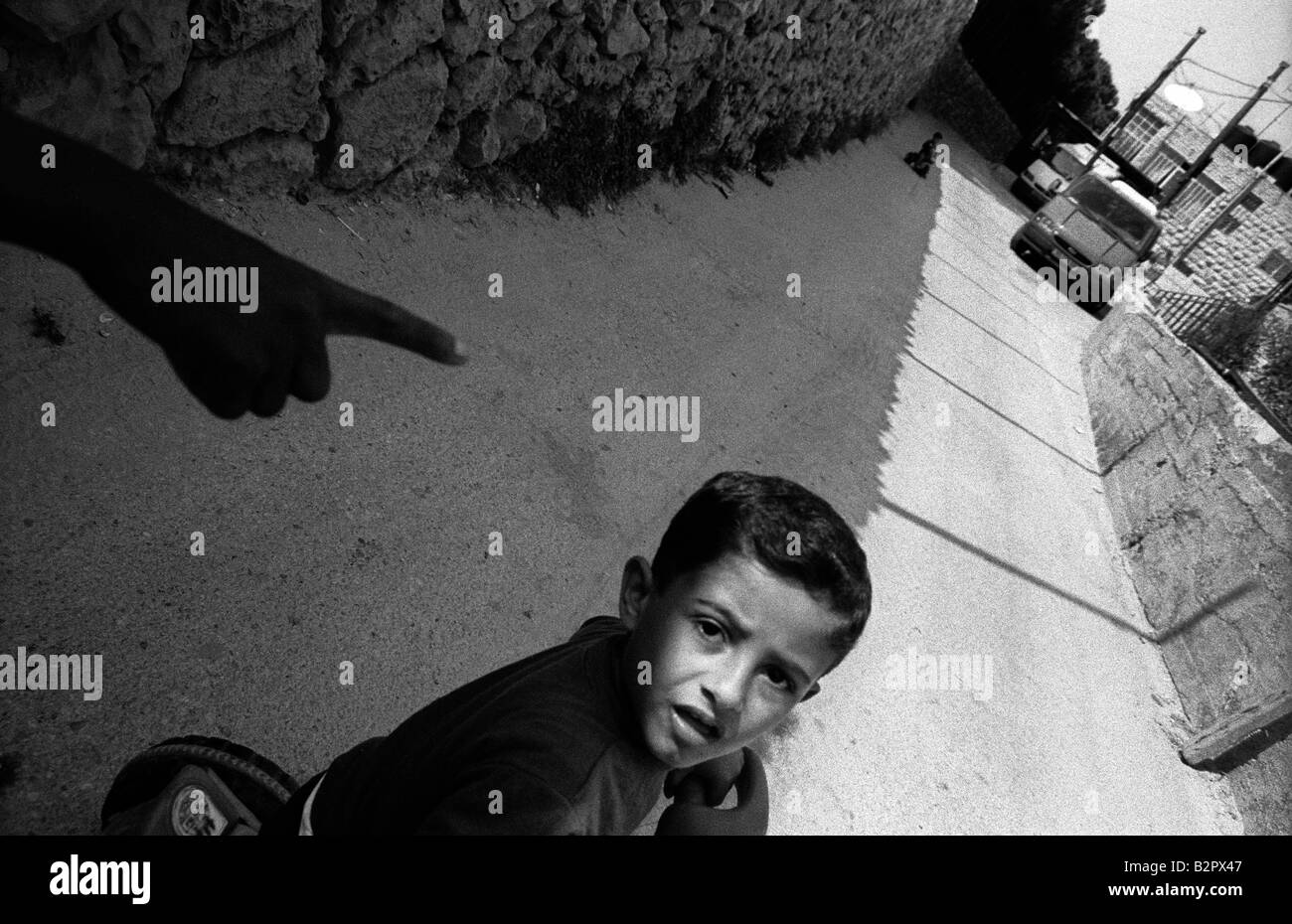 Une main qui montre à un jeune enfant palestinien sur un tricycle dans une rue à Naplouse pendant le couvre-feu imposé par les autorités israéliennes d'arm Banque D'Images