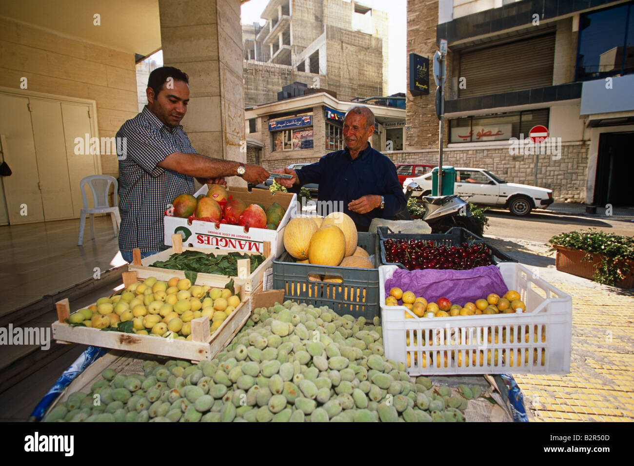 Titulaire de décrochage de fruits frais de vente au client sur street market stall, Lebenon, Moyen-Orient Banque D'Images