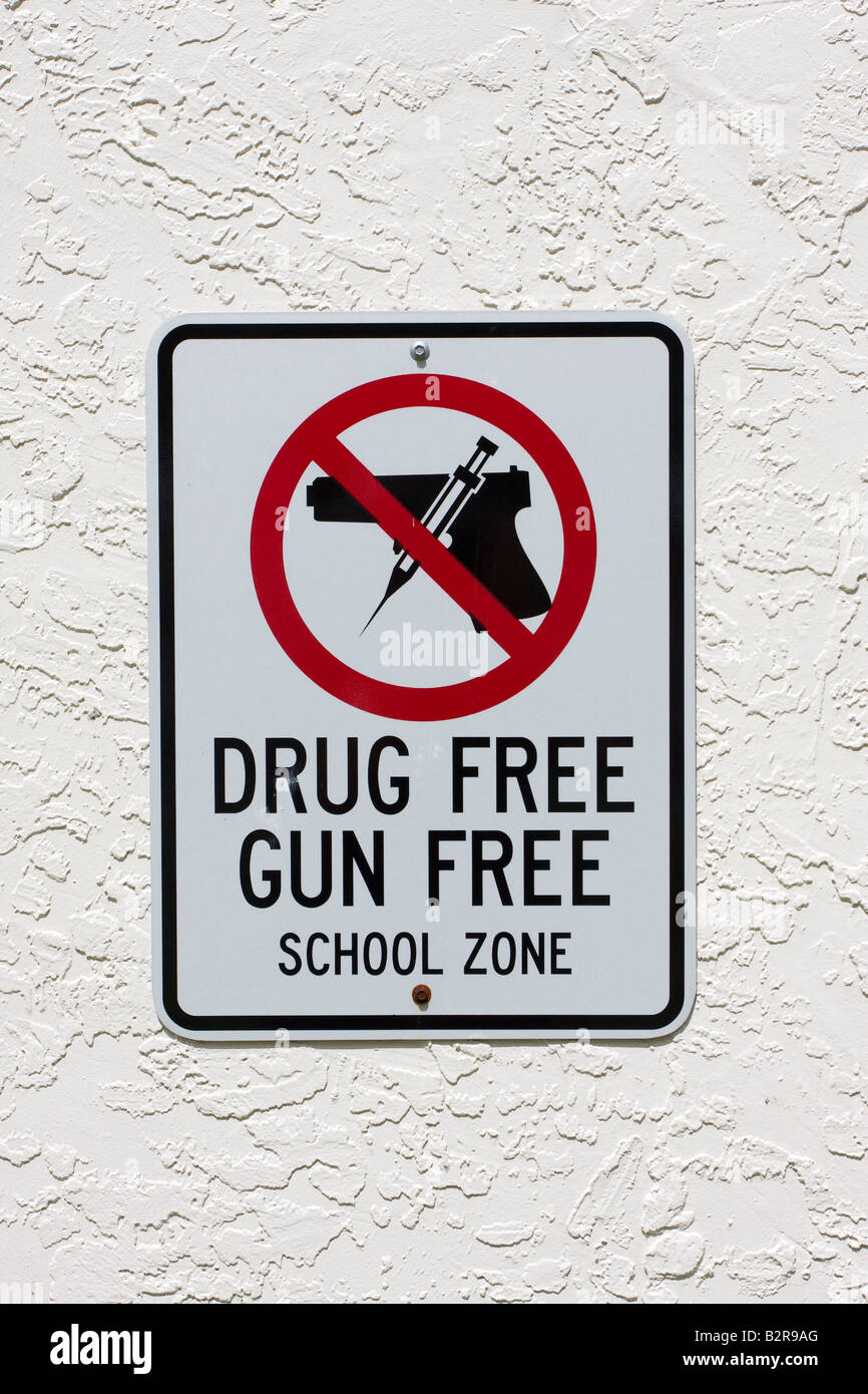 Affiche de la zone scolaire sans armes à feu et sans drogues avec arme à feu et aiguille dans le cercle rouge et clash au-dessus du pistolet Banque D'Images