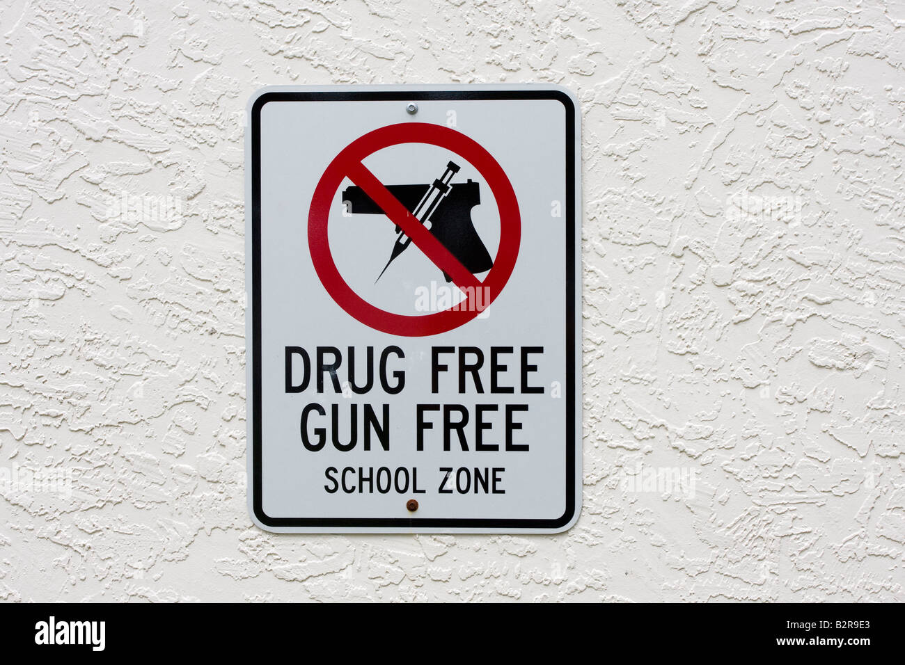 Affiche de la zone scolaire sans armes à feu et sans drogues avec arme à feu et aiguille dans le cercle rouge et clash au-dessus du pistolet Banque D'Images