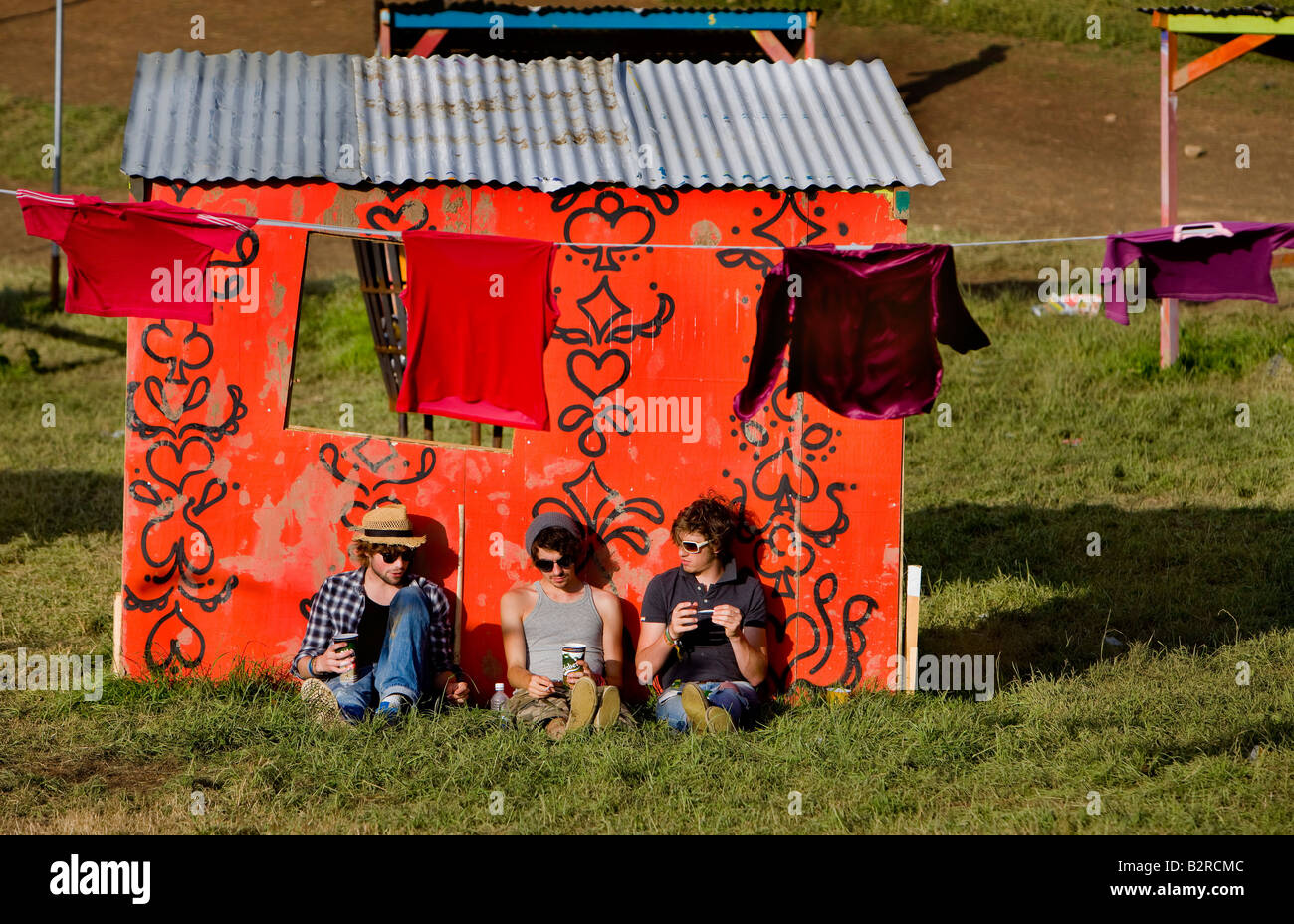 Les gens se détendre dans le chaleureux soleil de l'après-midi dans de nouvelles structures dans le parc,Festival de musique de Glastonbury, Somerset, Royaume-Uni Banque D'Images