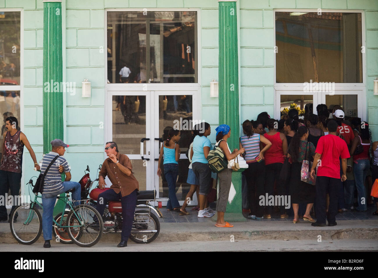 Un groupe de personnes attendent d'entrer dans un magasin à Baracoa, Cuba Banque D'Images