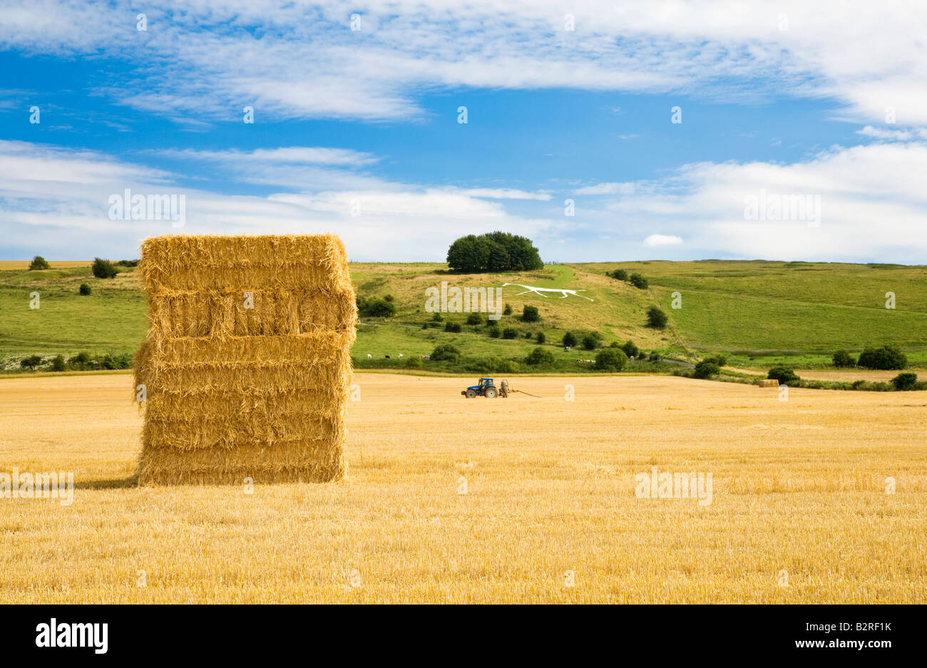 Scène typique du paysage du Wiltshire en été avec haybale, tracteur et Hackpen Cheval blanc figure à la craie, England, UK Banque D'Images