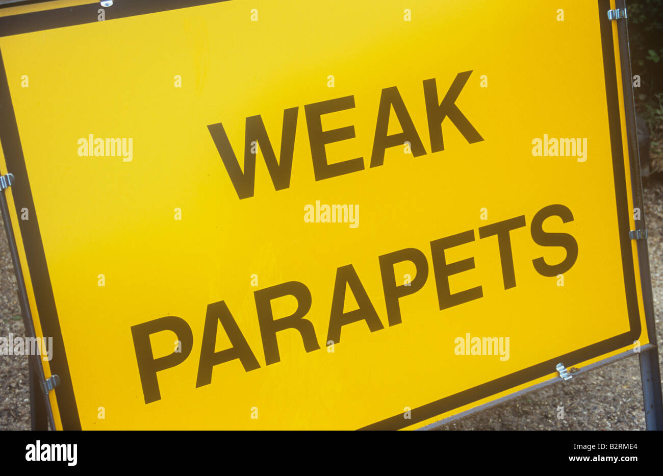 Stand-alone de jaune et noir travaux avertissement signe parapets faibles Banque D'Images