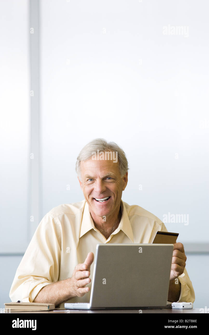 Faire de l'homme achat en ligne par carte de crédit, smiling at camera Banque D'Images