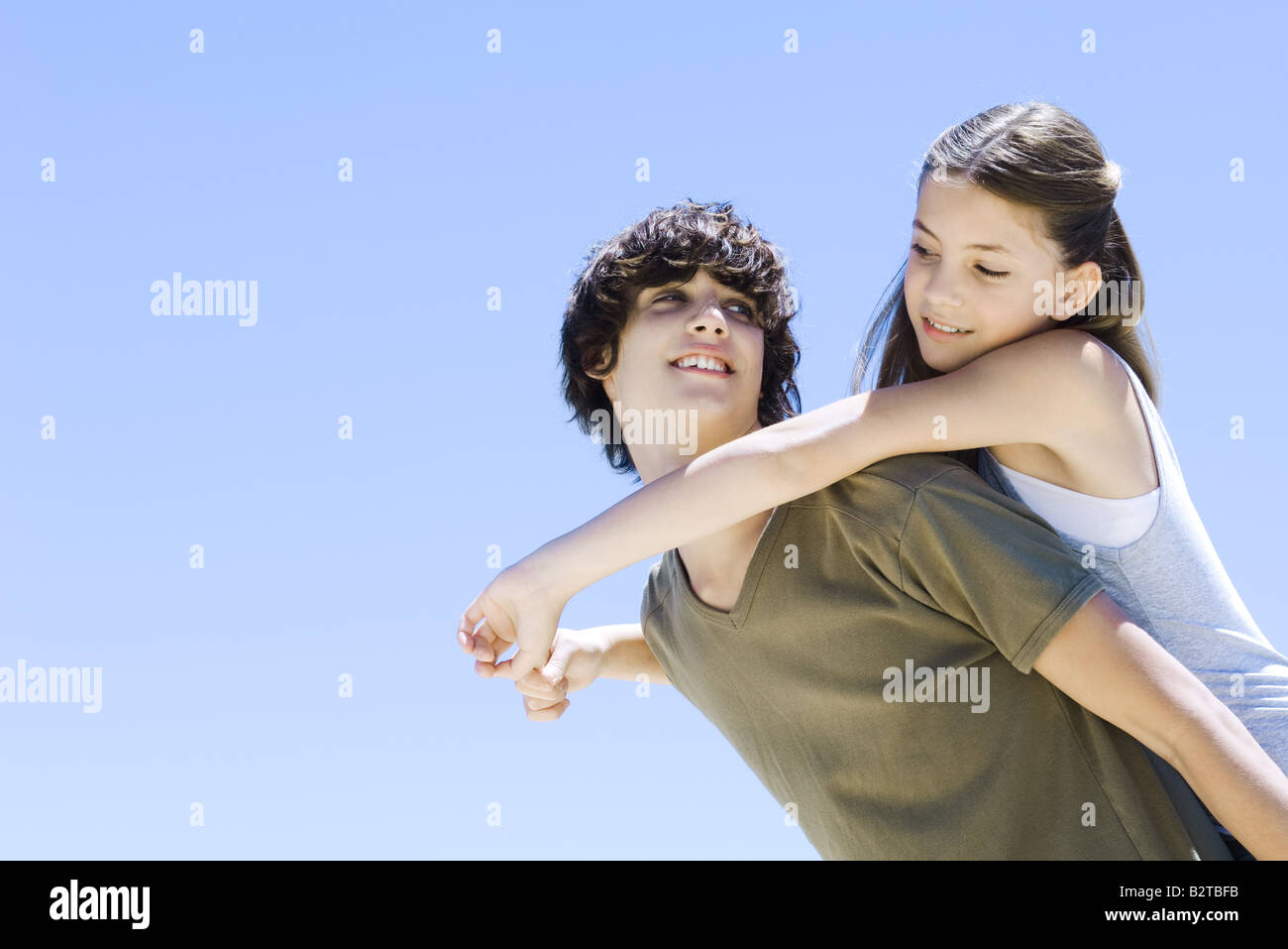 Teen boy carrying jeune sœur sur le dos, les deux, low angle view Banque D'Images