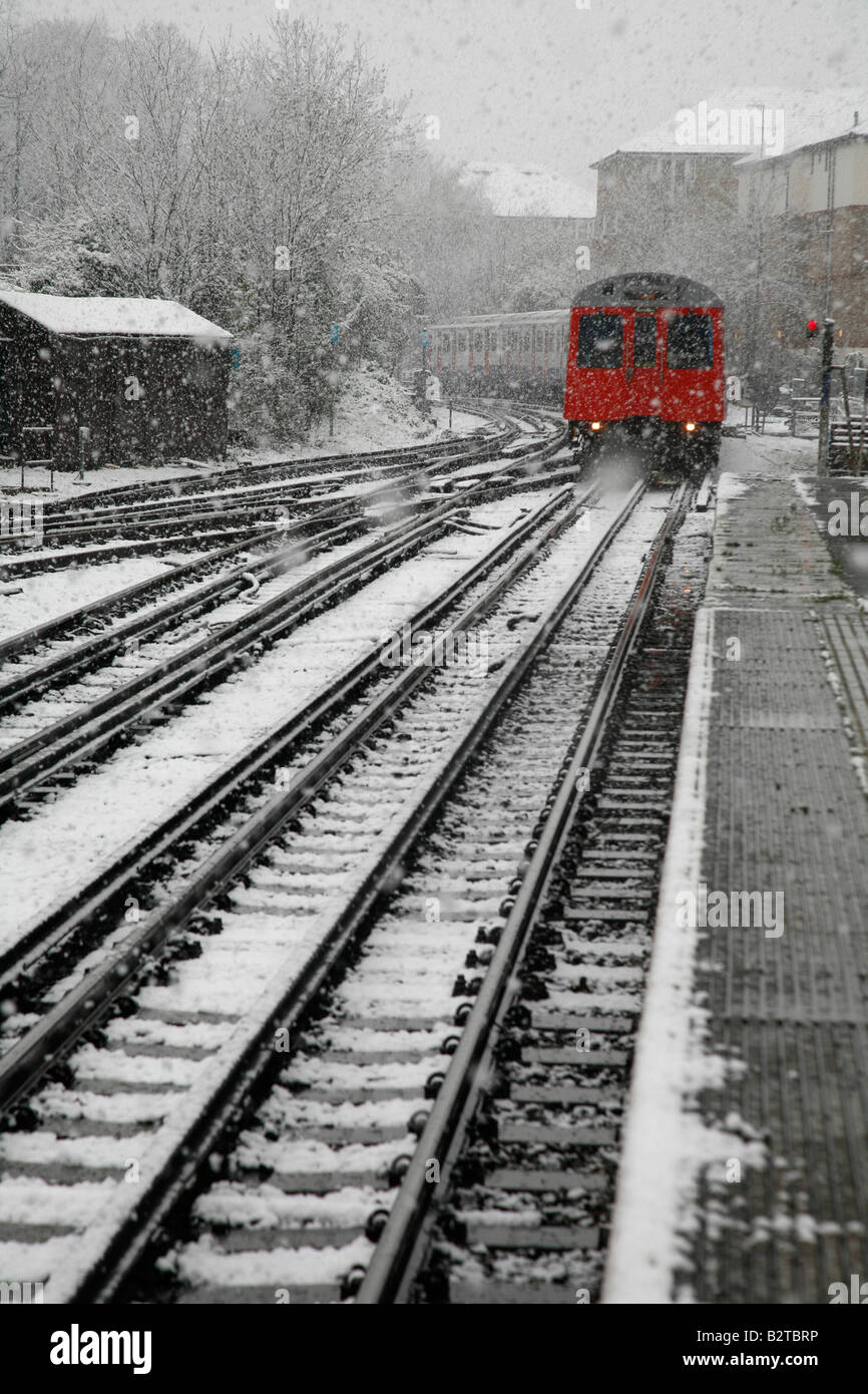 District Line train arrive dans la neige la station de métro East Putney, Londres Banque D'Images