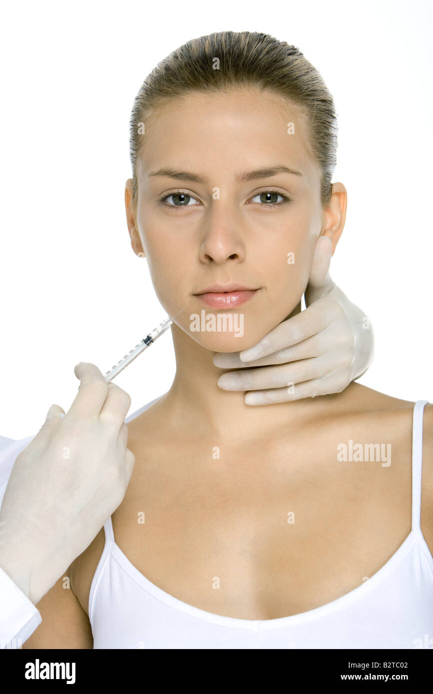 Young woman receiving collagen injection, looking at camera Banque D'Images