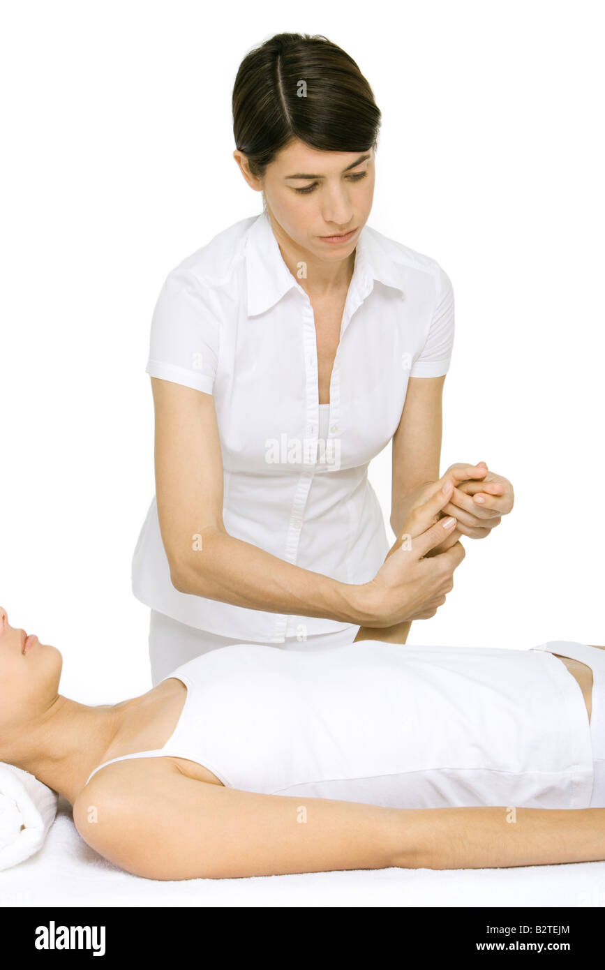Massage therapist massaging woman's hand Banque D'Images