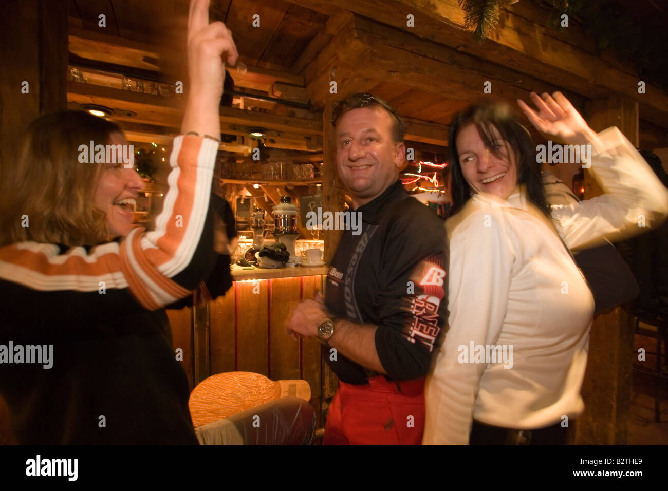 Deux jeunes filles et un homme danse et bénéficiant d'un après-ski party à Purzelbaum Alm, Flachau, Autriche, Salzburger Land Banque D'Images