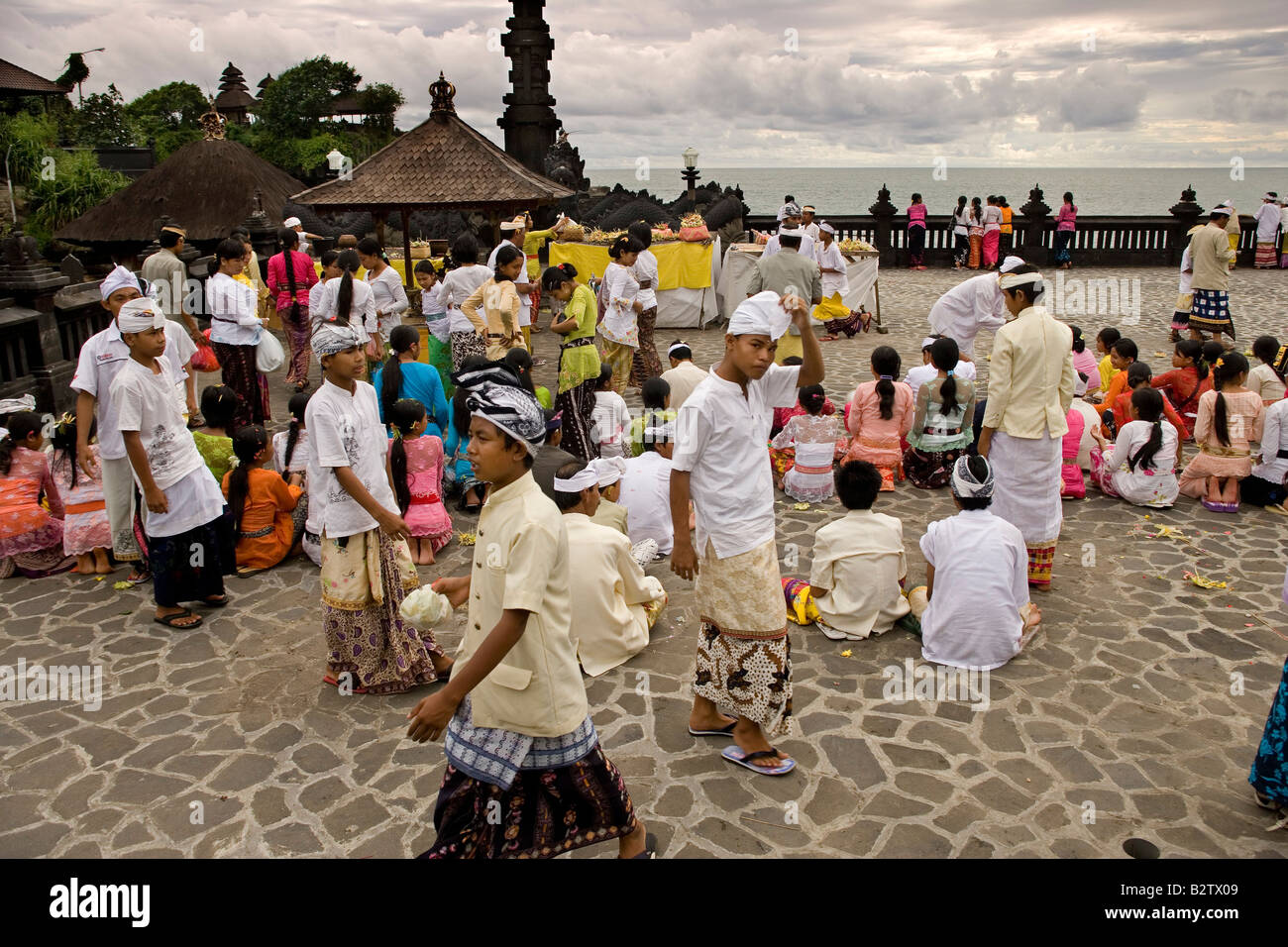 Les touristes indonésiens à faire des offrandes à Tanah Lot un ancien temple hindou par la mer à Bali en Indonésie Banque D'Images